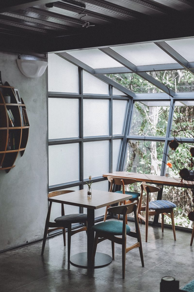 cafe looking office with extended metal framed window and wood furnitures
