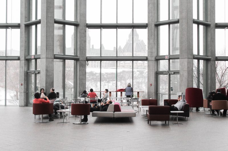 multi-level high ceiling lobby in the color themes of mostly while, metal grey, and a touch of red